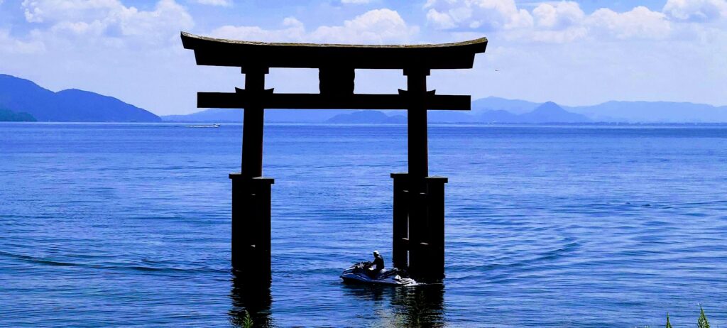 琵琶湖に浮かぶ鳥居をくぐる水上バイク